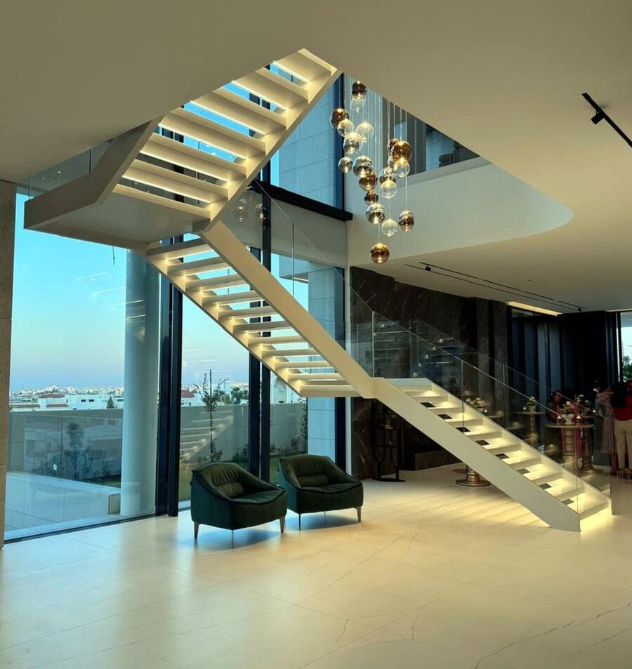 A floating lit staircase in a double-height hall