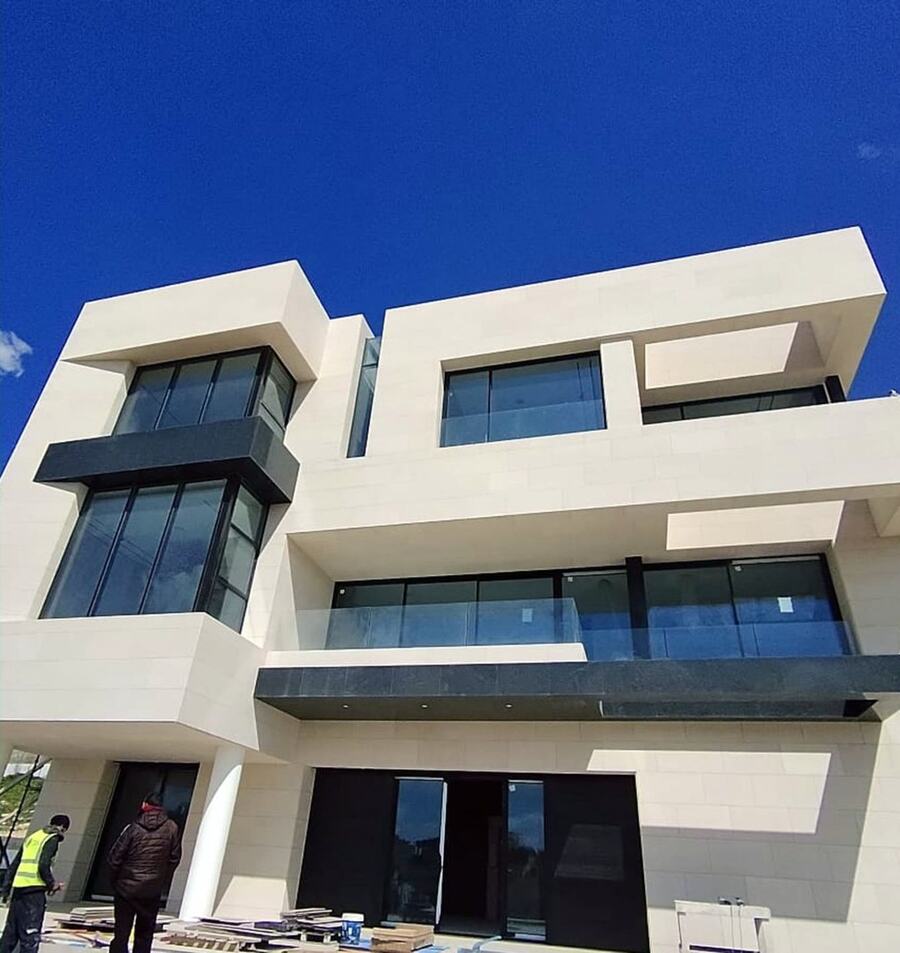 A completed white-stone villa with large glazing